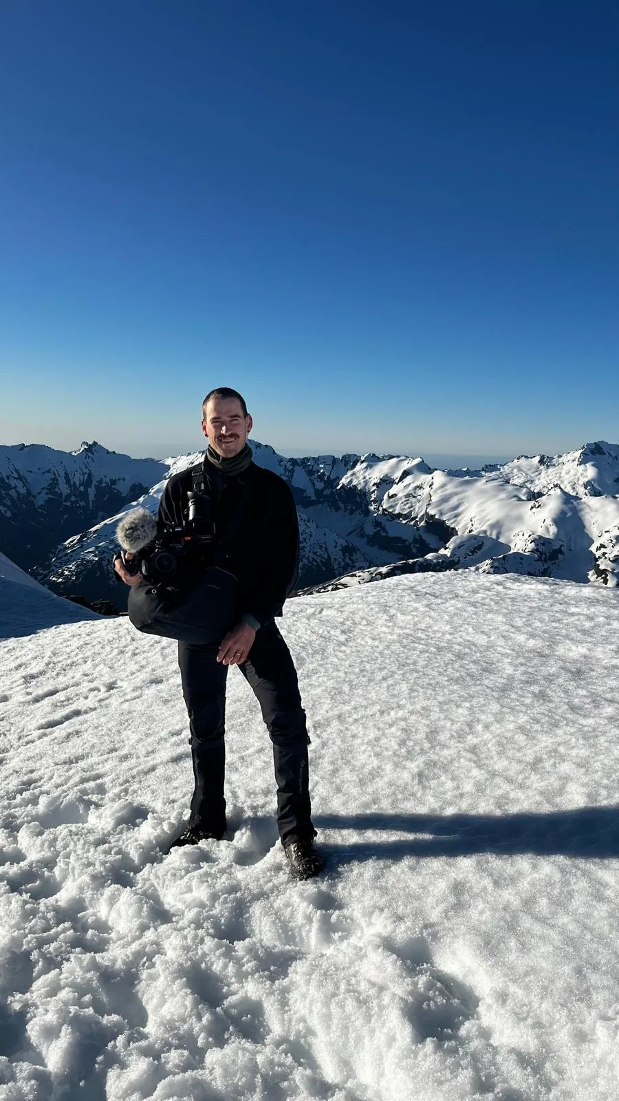 Dom from Reflections Media with a camera in the mountains